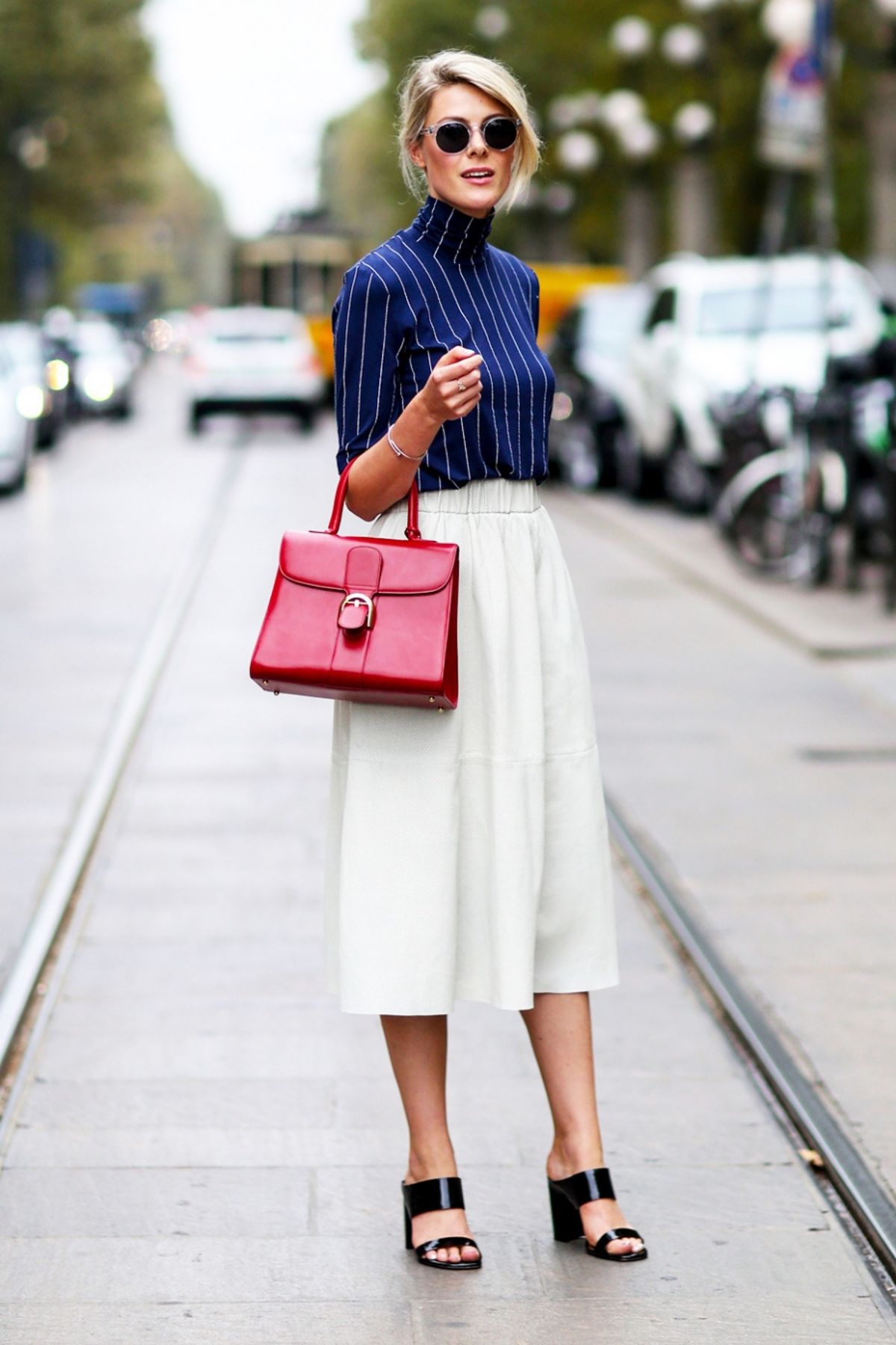 Белая юбка темно синего цвета и красная сумка.