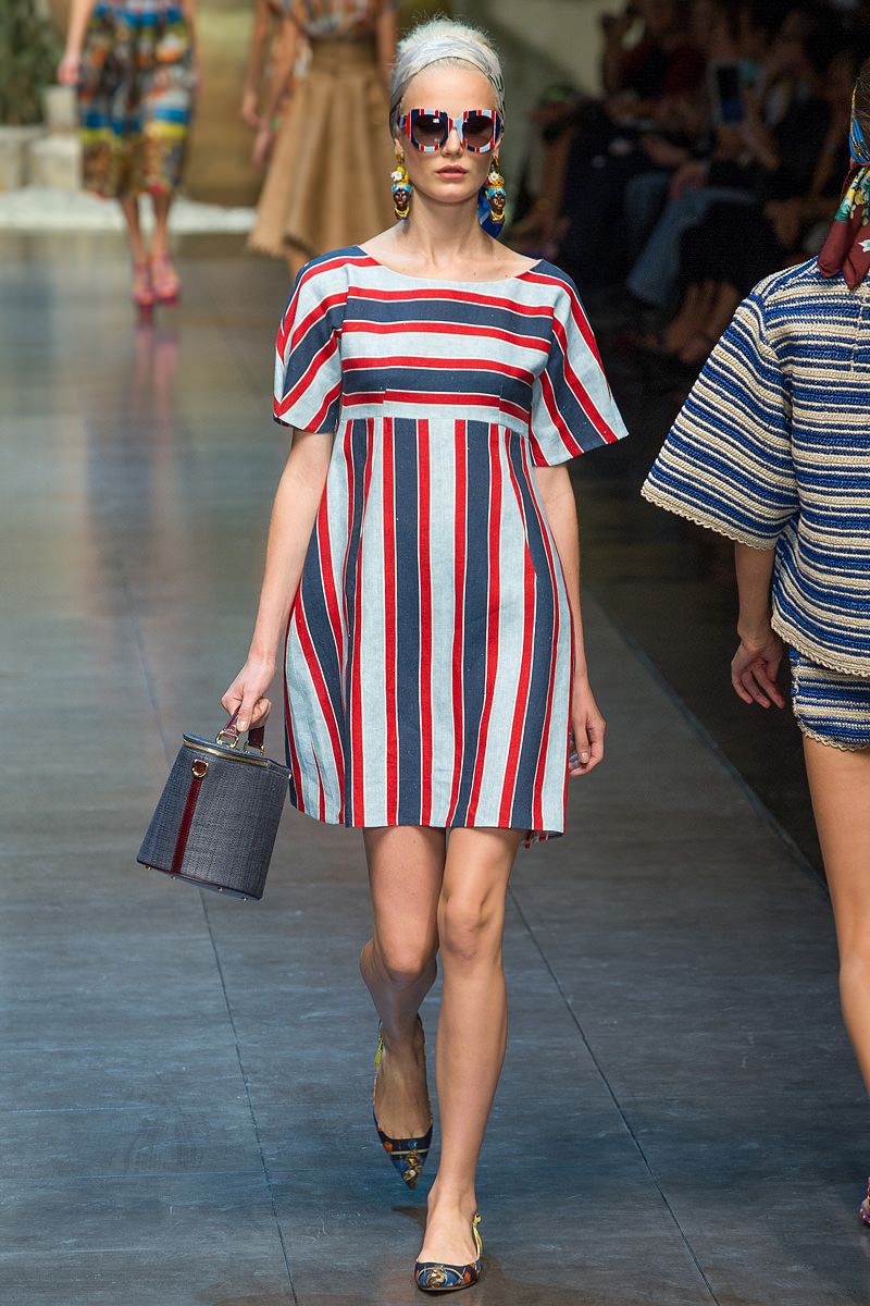 На фото: платье в вертикальную и горизонтальную красно- синию-белую полоску.