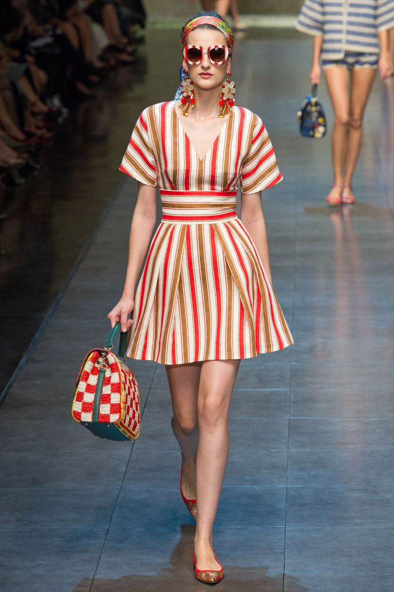 На фото: платье в вертикальную красную полоску с красно белой сумкой и красных босоножках.
