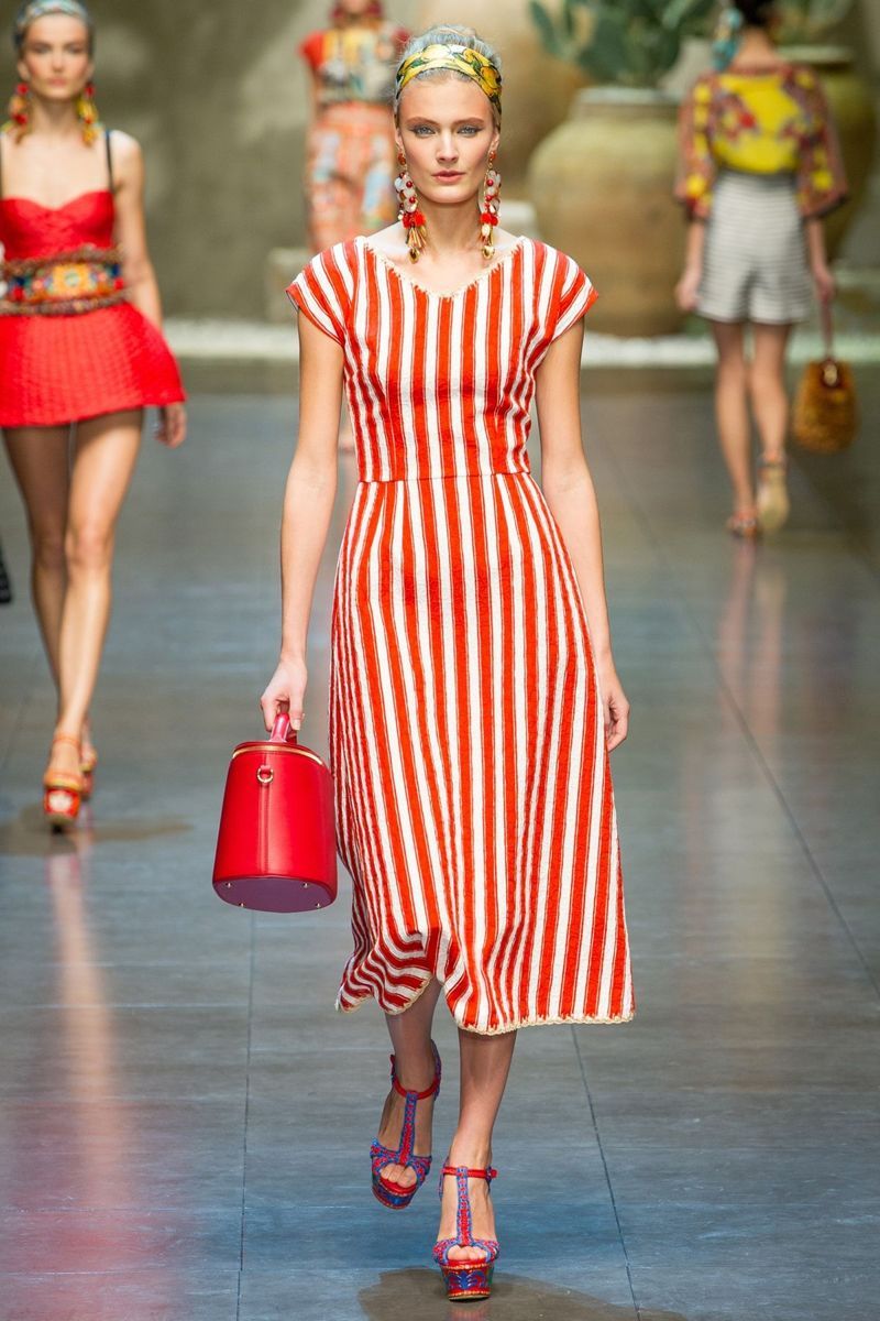 На фото: платье в вертикальную красную полоску с красной сумкой и красных босоножках.