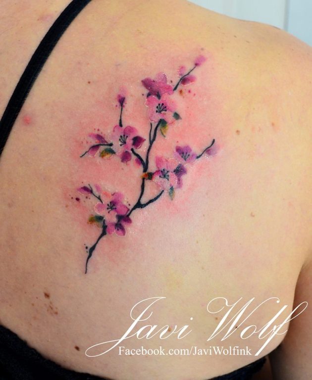 На фото: акварельная татуировка - цветок на спине.