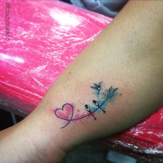 На фото: акварельная татуировка в виде сердца и птичек.