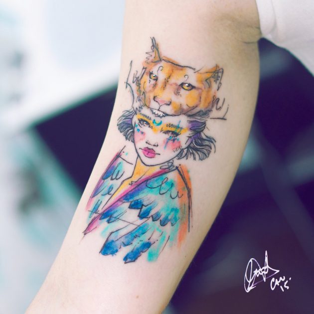 На фото: акварельная татуировка в виде девичьего лица и маски животного.