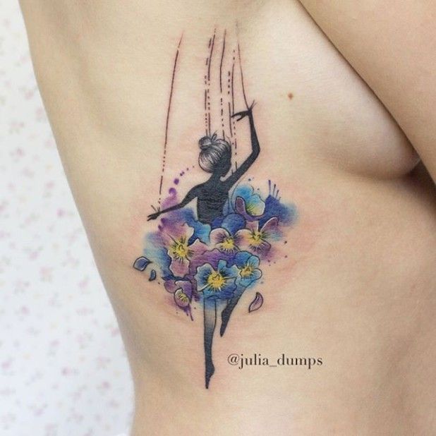 На фото: акварельная татуировка в виде яркой разноцветного танцующей девушки на правой стороне спины.