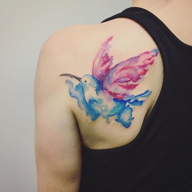 На фото: акварельная татуировка в виде яркой птицы на спине.